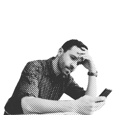 Ein Mann steht an einem Tisch und stützt seinen Kopf auf seinem Linken Arm ab, während er auf sein Smartphone schaut