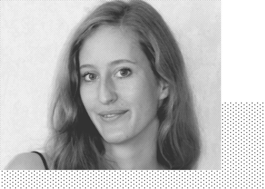 Ein Graustufenfoto einer Person mit langen Haaren, die mit neutralem Gesichtsausdruck in die Kamera blickt.