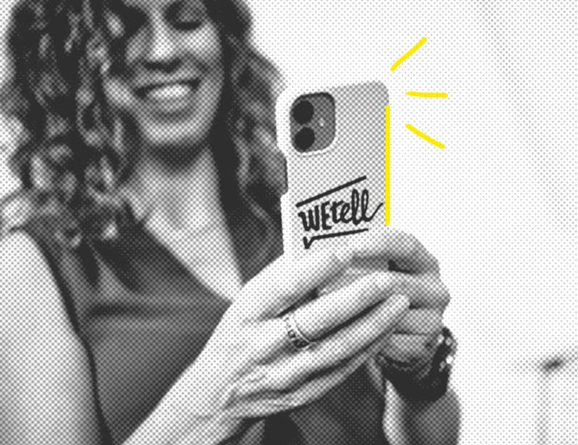 Eine Frau mit lockigem Haar lächelt und hält ein Smartphone mit dem WEtell-Logo auf der Hülle. Gelbe Linien betonen das Telefon.