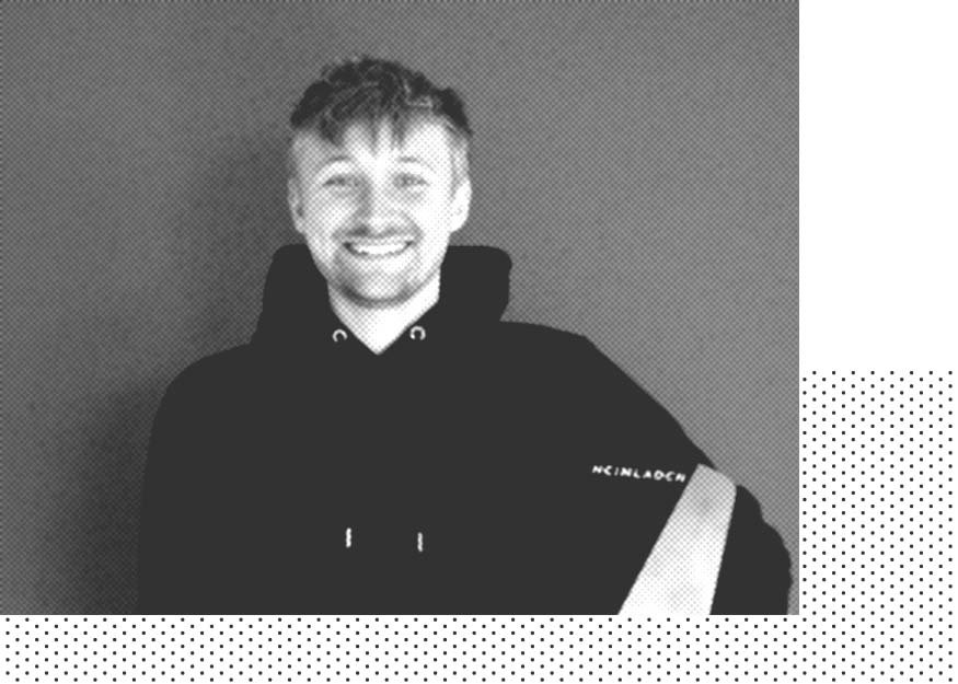Person mit Kapuzenpullover, lächelt in die Kamera und steht vor einem grauen Hintergrund mit einem gepunkteten Muster an den Bildecken.